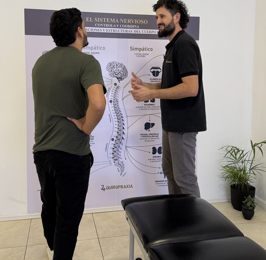 Explicación quiropráctica con modelo de columna vertebral